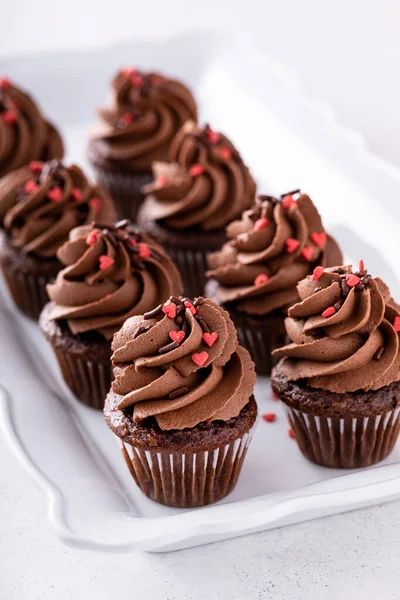Dark chocolate mini cupcakes with chocolate ganache frosting and heart sprinkles for Valentines day