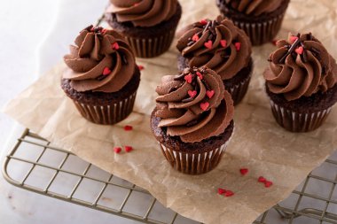 Dark chocolate mini cupcakes with chocolate ganache frosting and heart sprinkles for Valentines day