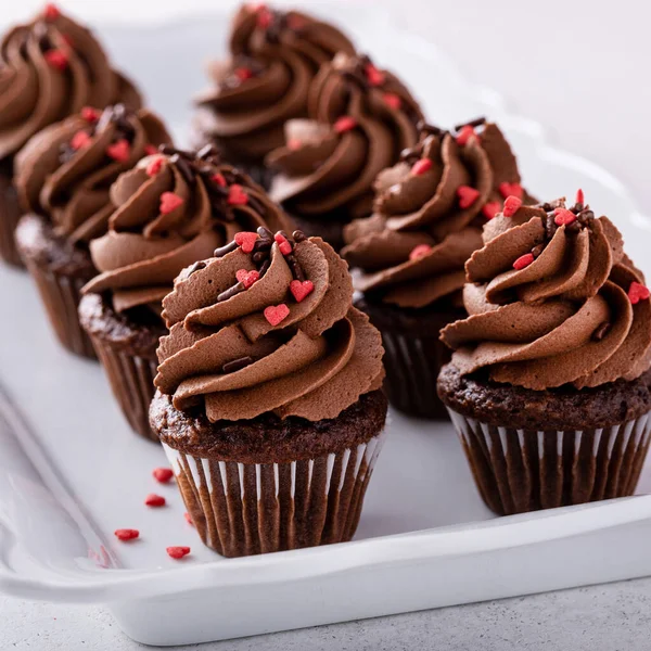 Dark chocolate mini cupcakes with chocolate ganache frosting and heart sprinkles for Valentines day