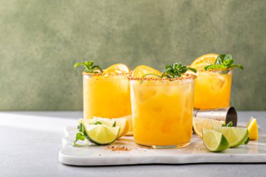 Triple citrus margarita with orange, lemon and lime garnished with mint with copy space