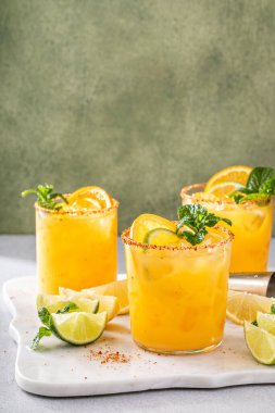 Triple citrus margarita with orange, lemon and lime garnished with mint with copy space