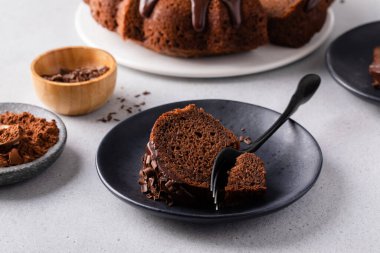 Chocolate cake baked in a bundt pan with chocolate ganache glaze and chocolate curls sliced