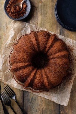Chocolate bundt cake dusted with cocoa powder on a cooling rack