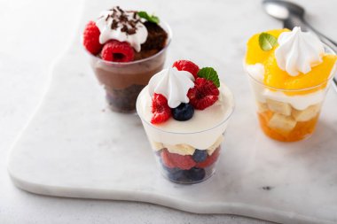 Variety of small desserts in cups, chocolate, berry and orange trifles or parfaits