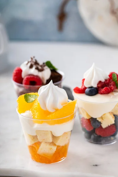 Variety of small desserts in cups, chocolate, berry and orange trifles or parfaits