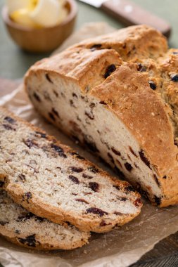 Soda bread in a cast iron pan with cranberries and pecans sliced and served with irish butter, irish recipe idea with St Patricks day