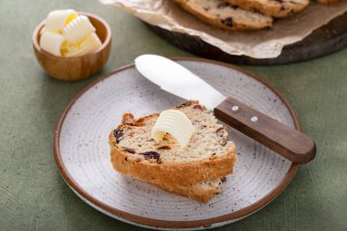 Soda bread in a cast iron pan with cranberries and pecans sliced and served with irish butter, irish recipe idea with St Patricks day