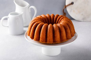 Vanilla bundt cake on a cake stand, golden freshly baked ready to eat