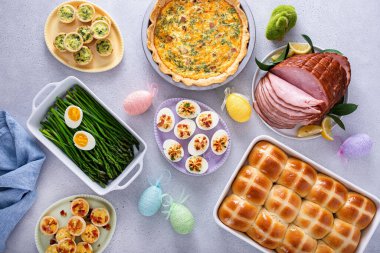 Jambonlu Paskalya brunch masası, kiş, sıcak haç çörekleri ve baharatlı yumurtalar.