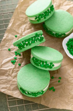 Green sandwich cookies with salted caramel and shamrock sprinkles, dessert idea for St Patricks day