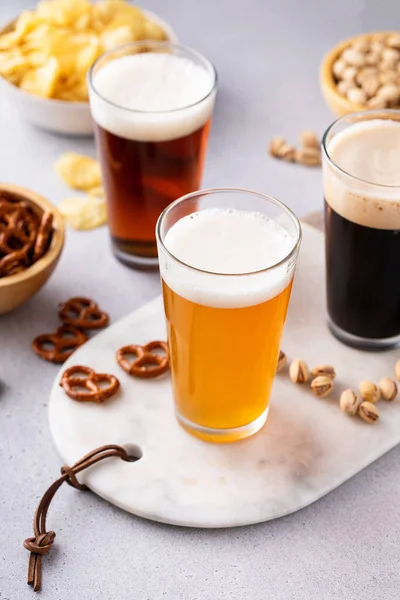 ダークスタウト 伝統的なラガーとベルギーの白のビールのバリエーションは テーブル上のスナックを提供 — ストック写真