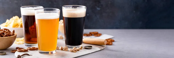 ダークスタウト 伝統的なラガーとベルギーの白のビールのバリエーションは コピースペースとテーブル上のスナックを提供 — ストック写真