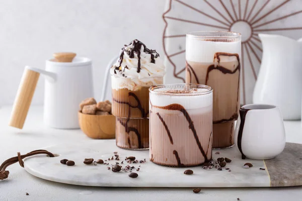 在各种不同的杯子里放上巧克力糖浆和精美的咖啡饮料 — 图库照片