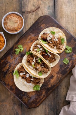 Kesme tahtasında soğan ve kişniş soslu domuz carnitas taco