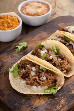 Kesme tahtasında soğan ve kişniş soslu domuz carnitas taco