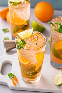 Limonlu ve naneli uzun bardaklarda portakal ve limonlu mojito kokteyli.