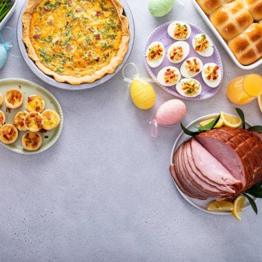 Jambonlu Paskalya brunch masası, kiş, sıcak haçlı çörekler, baharatlı yumurtalar ve fotokopi alanı manzaralı mimozalar.
