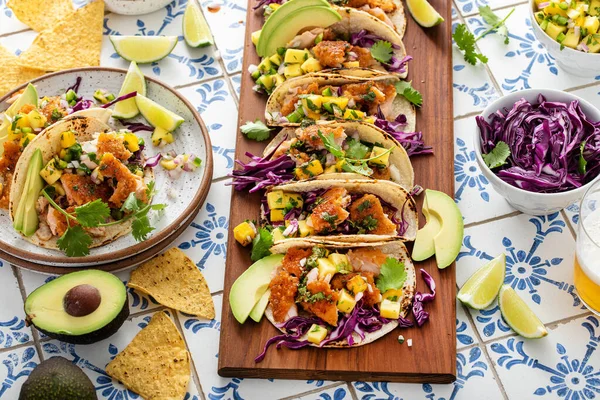 Fish tacos with mango salsa and red cabbage, salmon tacos board with beer and hot honey