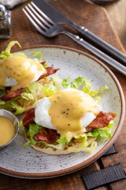 Pastırmalı Benedict usulü yumurta ve İngiliz keklerinin üzerine marul. Geleneksel kahvaltı fikri.