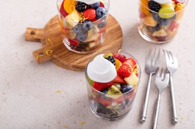 Meyve salatası, çilek, narenciye, nane ve bal sosu bir tutam kremayla servis edilir.