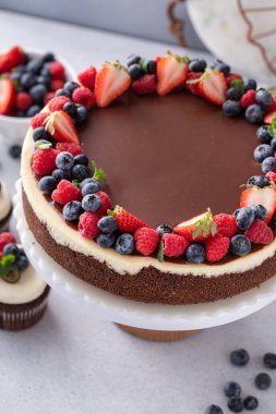 Çikolatalı ve vanilyalı cheesecake, üstüne koyu çikolatalı ganache ve yaz meyveli.