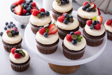 Krem peynirli çikolatalı kekler ve taze yaz meyveleri.