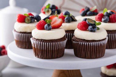 Krem peynirli çikolatalı kekler ve taze yaz meyveleri.