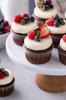 Krem peynirli çikolatalı kekler ve taze yaz meyveleri.
