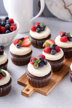 Krem peynirli çikolatalı kekler ve taze yaz meyveleri.