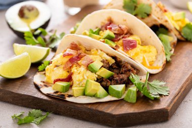 Kahvaltıda sosisli taco, omlet, pastırma ve avokado.