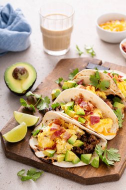 Kahvaltıda sosisli taco, omlet, pastırma ve avokado.