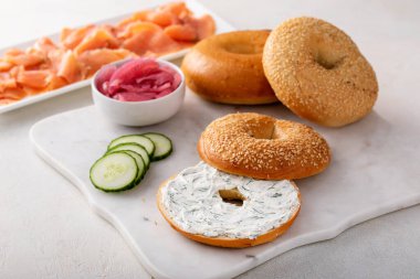 Dereotu peyniri, somon ve salatalıkla servis edilen taze pişmiş simit.