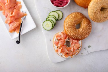 Dereotu peyniri, somon ve salatalıkla servis edilen taze pişmiş simit.