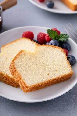 Taze ahududu ve yabanmersinli dilimlenmiş klasik kek.