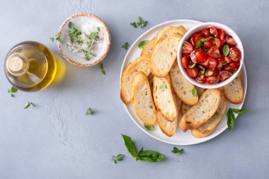 Kızarmış baget ve taze bitkilerle domates fesleğenli bruschetta yapıyorum.