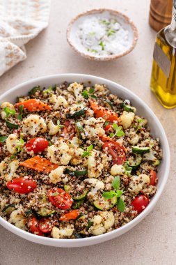 Warm quinoa salad with roasted vegetables and fresh tomatoes, healthy side dish idea clipart