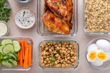 Tavuklu, kinoalı, bezelyeli, sebzeli ve haşlanmış yumurtalı konteynırlarda yüksek proteinli sağlıklı öğle yemeği.
