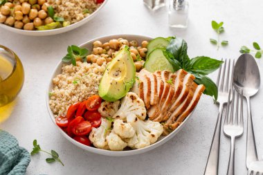Healthy high protein lunch bowl with grilled chicken, roasted cauliflower, herbed chickpeas and quinoa clipart