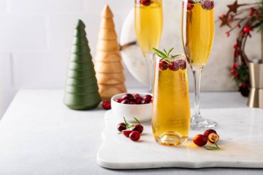 Elma şarabı ve şampanya ile Noel mimozaları ya da köpüklü şarap, biberiye ve kızılcıkla süslenmiş Noel kokteylleri.