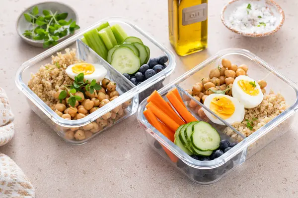 Vegetarian lunch meal prep containers high protein with quinoa, herbed chickpeas, vegetables and boiled eggs