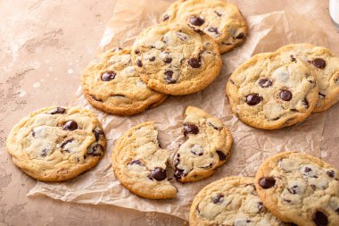 Çikolata parçalı kurabiyeler taze pişmiş parşömen kağıdı ve gevrek tuz.