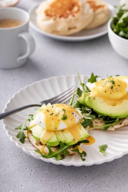 İngiliz kekleri roka, avokado ve haşlanmış yumurta, sağlıklı yumurta Benedict fikri.