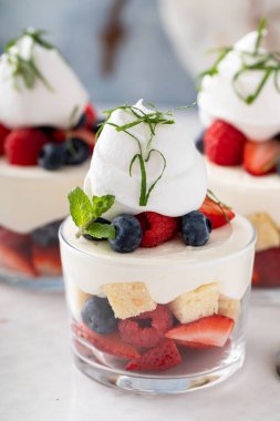 Kek ve böğürtlen katmanlı tatlı bir fincanda, tatlı cam bir fikirde.