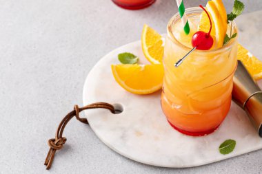 Portakal suyu ve romlu tropik tiki kokteyli. Portakal dilimi ve vişneli kokteylle süslenmiş tiki bardağı.