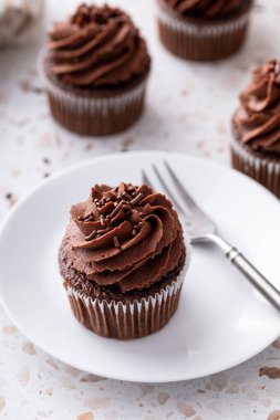 Çırpılmış çikolata ganache ve çikolata parçacıklarıyla kaplı çikolatalı kekler.