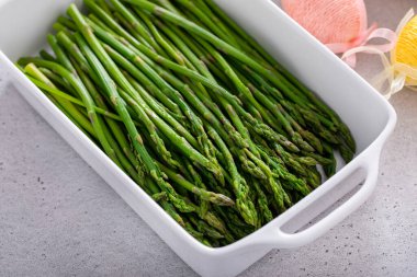Blanched young asparagus in a baking pan, recipe for Easter brunch or dinner clipart