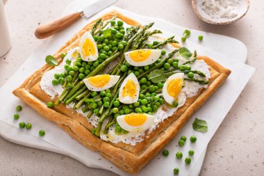 Kuşkonmaz ve bezelyeli yumurtalı tart, puf böreği ve krem peynir, bahar tarifi fikri.