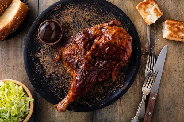 Half of smoked chicken with barbecue sauce served with fresh salad and sauce