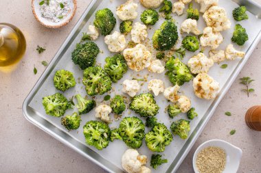 Brokoli ve karnabahar çiçekleri baharatlar, ekmek kırıntıları ve zeytinyağı ile kavrulmaya hazır.