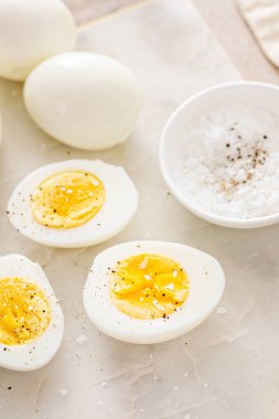 Sert haşlanmış yumurta soyulmuş ve tuz ve biberle ikiye bölünmüş.